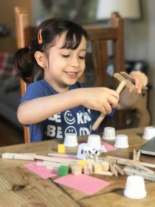 child building with home crafts like popsicle sticks